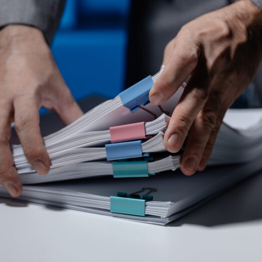 An employee was tidying up a pile of documents piled on his desk An employee was tidying up a pile of documents piled on his desk before returning home from work, A businessman is tidying up his desk because there are many documents he has completed.