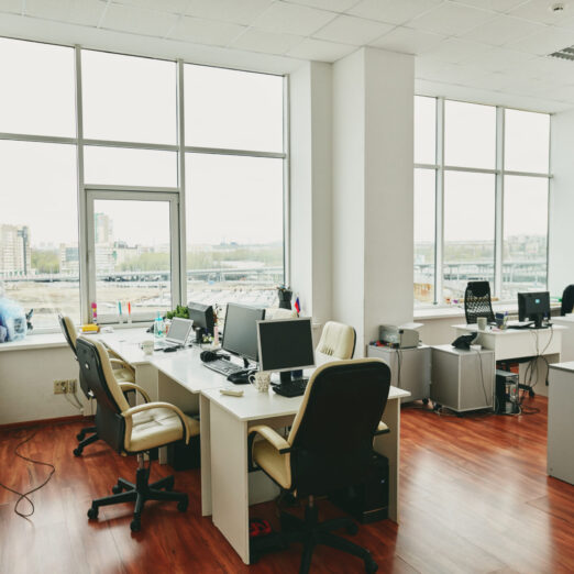 Interior of contemporary office in modern center with furniture and supplies Interior of contemporary large office in modern center with desks, computer monitors, white leather armchairs and other stuff